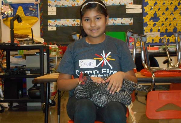 OMF Inc. Student Sitting With Chicken